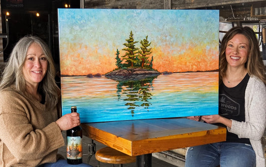 Custom Painting of the Lake of the Woods Brewing Company logo come to life as an actual island lit up by Sunset on Lake of the Woods, Ontario. This Painting was featured in the Women's Day Beer (2021) "Three Sisters"